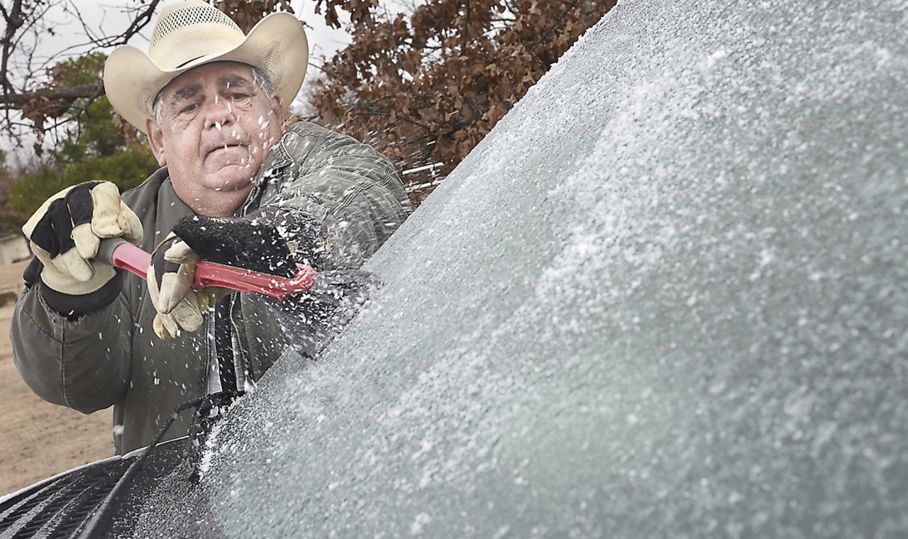 Stephen LeFlore scrapes ice from his windshield in McAlester, Oklahoma, on Thursday, December 5.