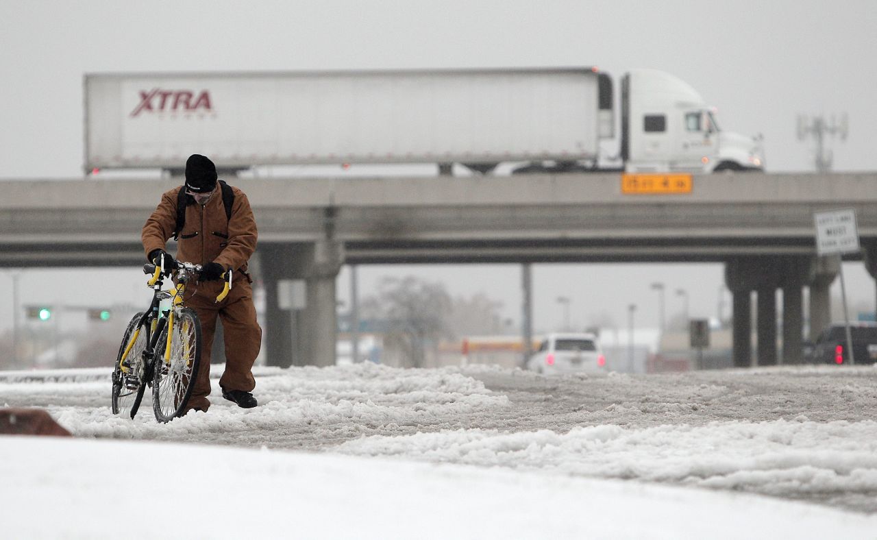 Jeff Chupp walks his ice-covered bicycle along Great Southwest Parkway in Grand Prairie on December 6.