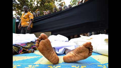 People stand near bodies found lying in a mosque and in its surrounding streets in Bangui on December 5.