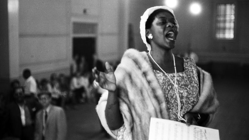 Washington was raised in church, singing gospel music, playing piano and directing her church choir.  in this 1958 photo, she sings at a church service in Newport, Rhode Island. 