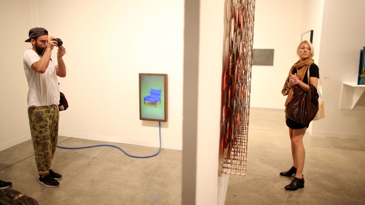 Visitors look at the work on display at the Miami Convention Center on Thursday, December 5.