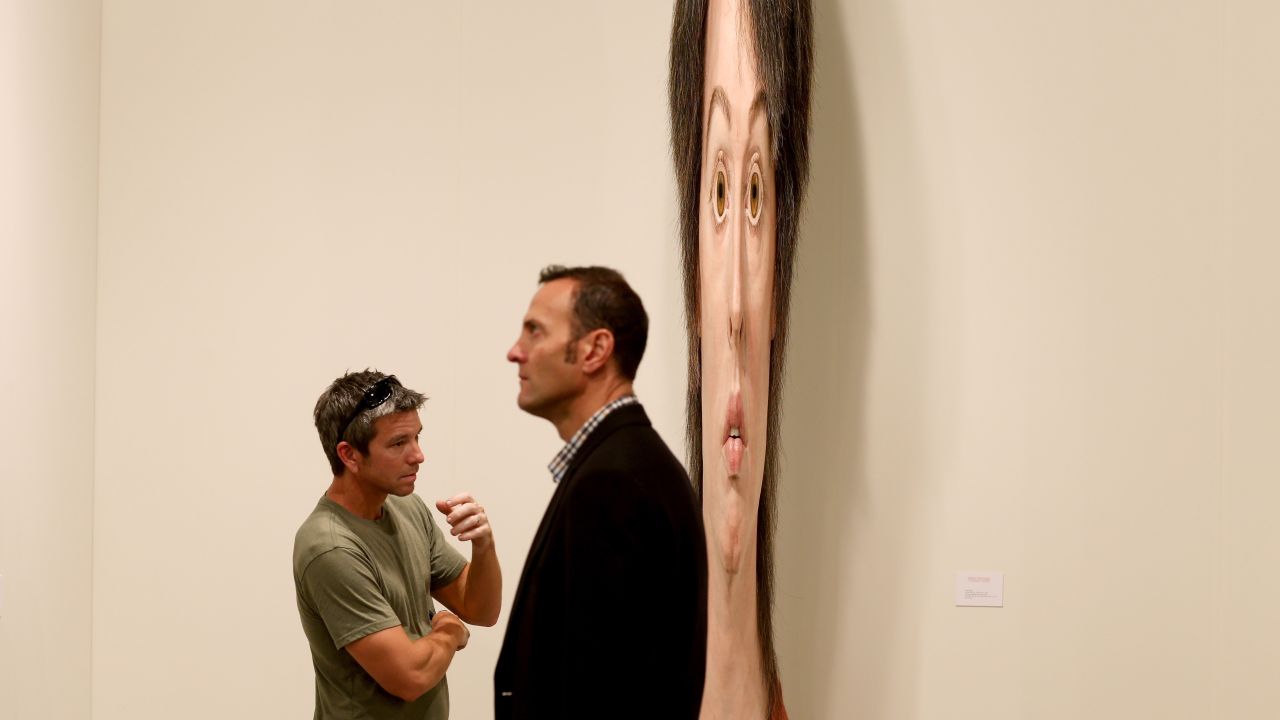 Lance Vickery, left, looks at a work by Evan Penny titled "female stretch variation # 2" on December 5. 