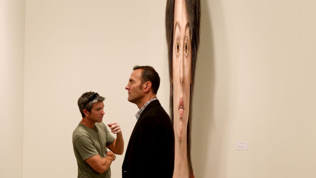 Lance Vickery, left, looks at a work by Evan Penny titled "female stretch variation # 2" on December 5.
