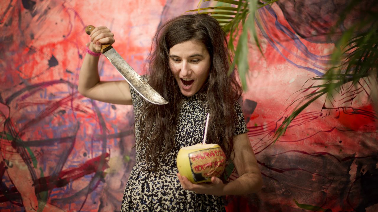 Naomi Fisher "jokes around" after opening a coconut as part of her installation, "Paradise Walking" on December 4. 