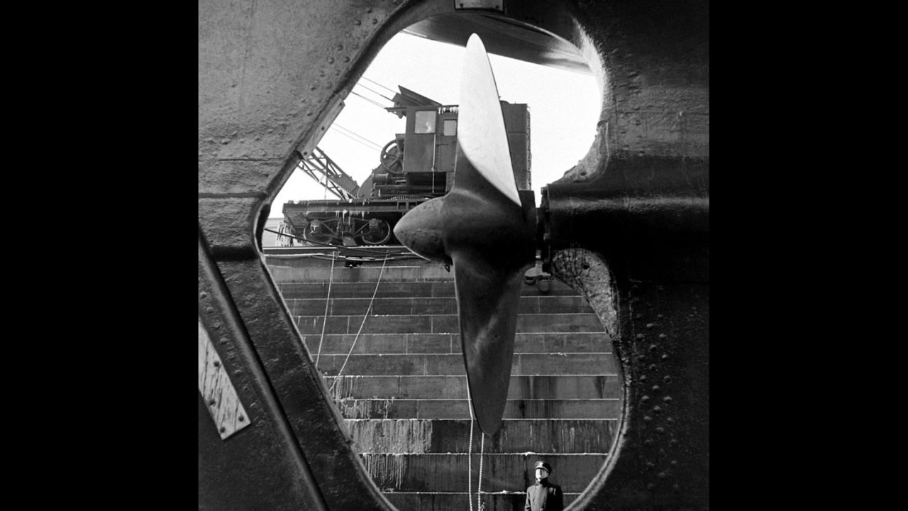 A Naval officer looks at the massive propeller of a ship at the Brooklyn Navy Yard in 1941.