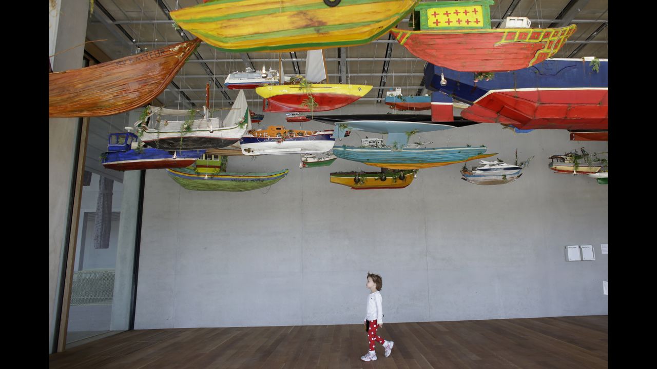 Ava Crowley, 4, of Miami, walks among an installation of boats by the artist Hew Locke titled "For Those in Peril on the Sea" at the Perez Art Museum Miami on December 7.