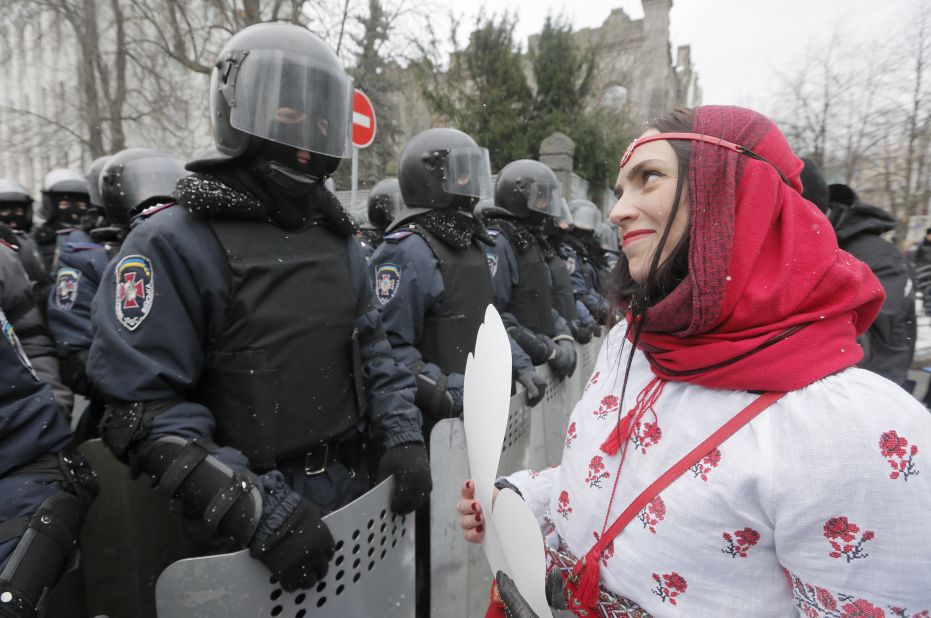 A pro-EU activist holds a cut-out paper heart as she faces police at the presidential office in Kiev on December 8. 