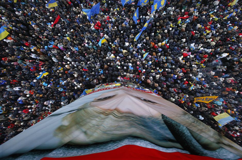 Pro-EU activists gather around a huge poster of Yulia Tymoshenko, the jailed former Ukrainian Prime Minister, on December 8.