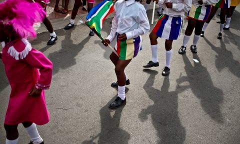 Children in a drum majors group perform a dance outside Mandela's old house on Saturday, December 7.