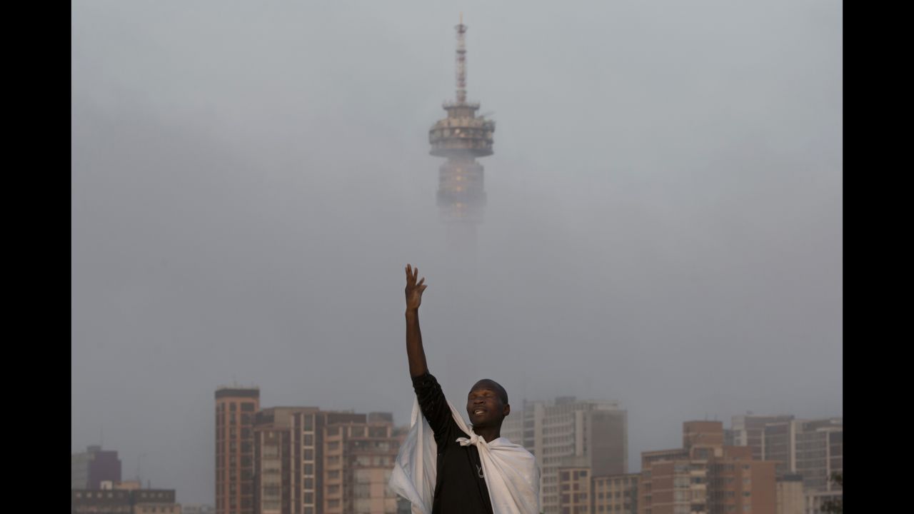A mourner prays on a hill overlooking Johannesburg on Sunday, December 8.