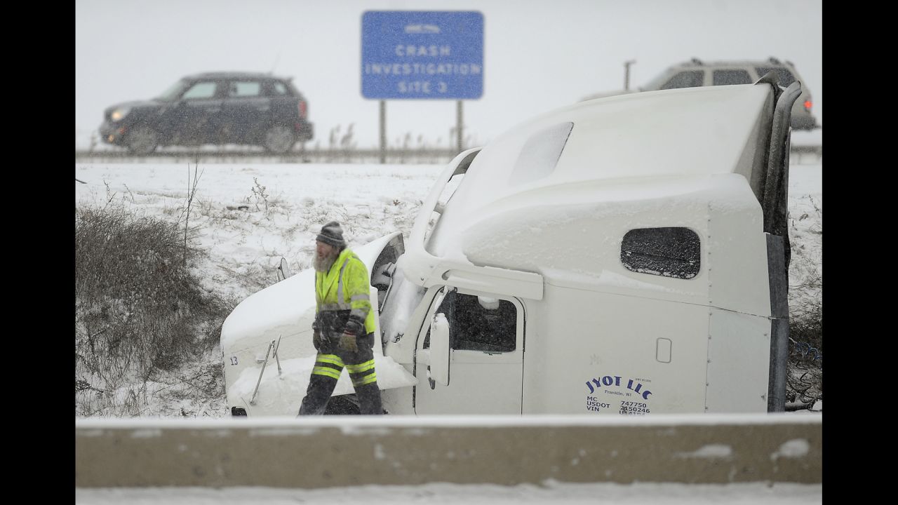 A towing company employee works where a semitrailer jackknifed off Interstate 94 in Racine County, Wisconsin, on December 8.
