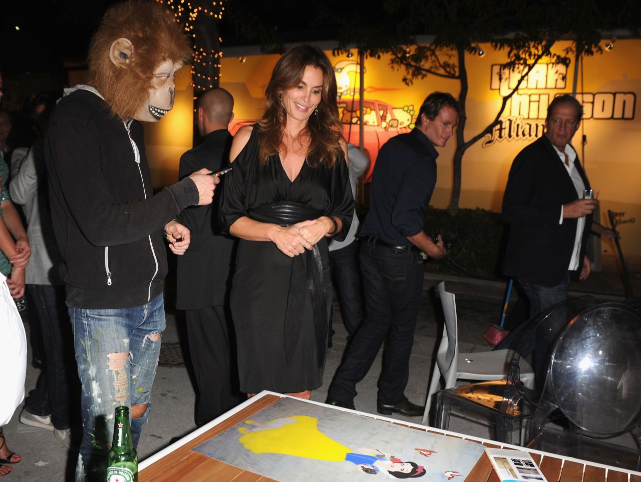 Cindy Crawford, 47, attended a photographic retrospective of her career during Art Basel Miami Beach. Here, she chats with anonymous Swedish artist Herr Nilsson about one of his paintings, which depicts Snow White.