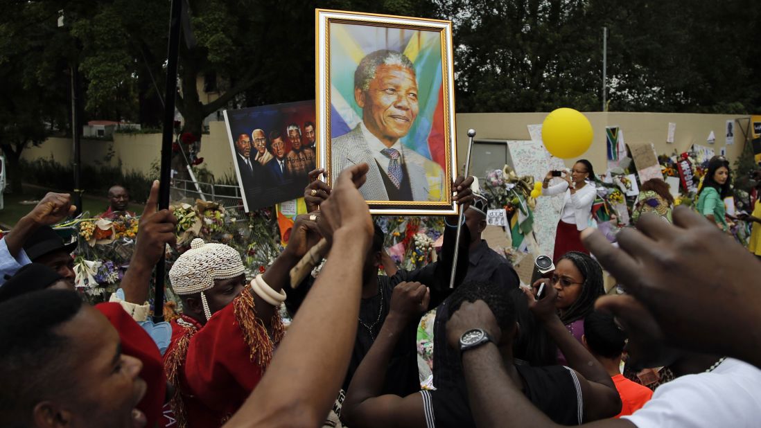 Mourners sing outside the home of former South African President Nelson Mandela in Johannesburg on Monday, December 9. The revered statesman, who emerged from prison to lead South Africa out of apartheid, died on Thursday, December 5. Mandela was 95.