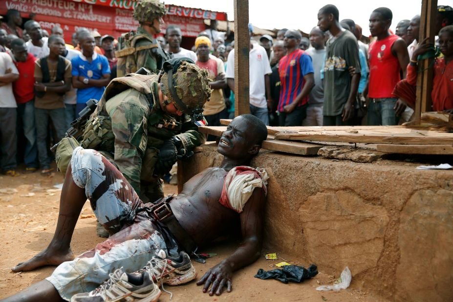 A French soldier speaks to a suspected Christian militia member who was wounded by a machete in the Kokoro neighborhood of Bangui on December 9. Vigilante crowds said they spotted him with grenades and turned him in to French forces.