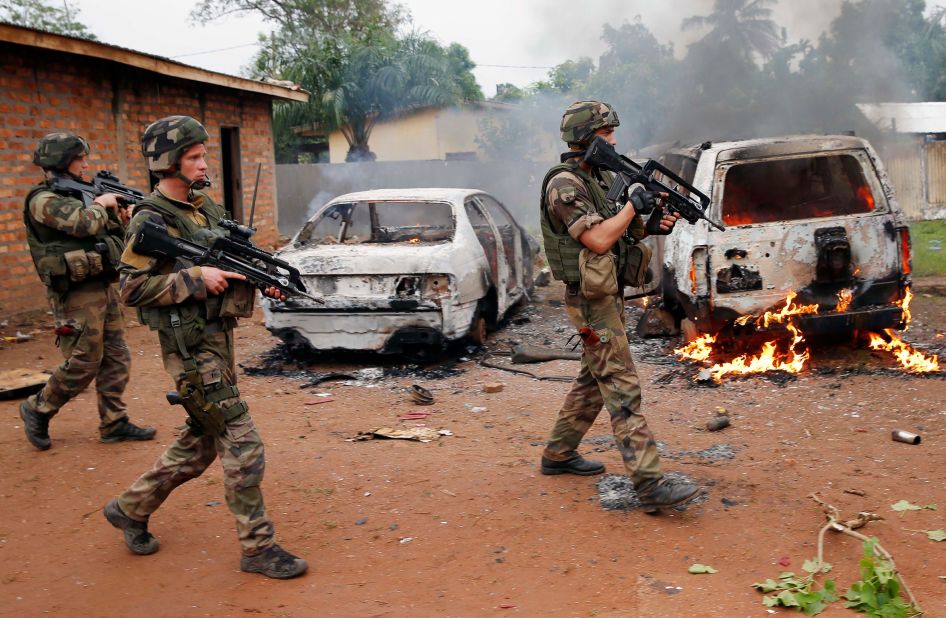 French troops walk past two Seleka vehicles suspected of being set on fire by Christian mobs in Bangui. 