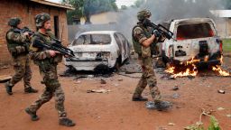 French troops patrol past two Seleka, the alliance of mostly Muslim rebel groups, vehicles set on fire by Christian mobs in Bangui, Central African Republic, Monday  Dec. 9, 2013.  Both Christian and Muslim mobs went on lynching sprees as French Forces deploy in the capital. At least one Seleka suspect was stoned to death by the crowds. (AP Photo/Jerome Delay)