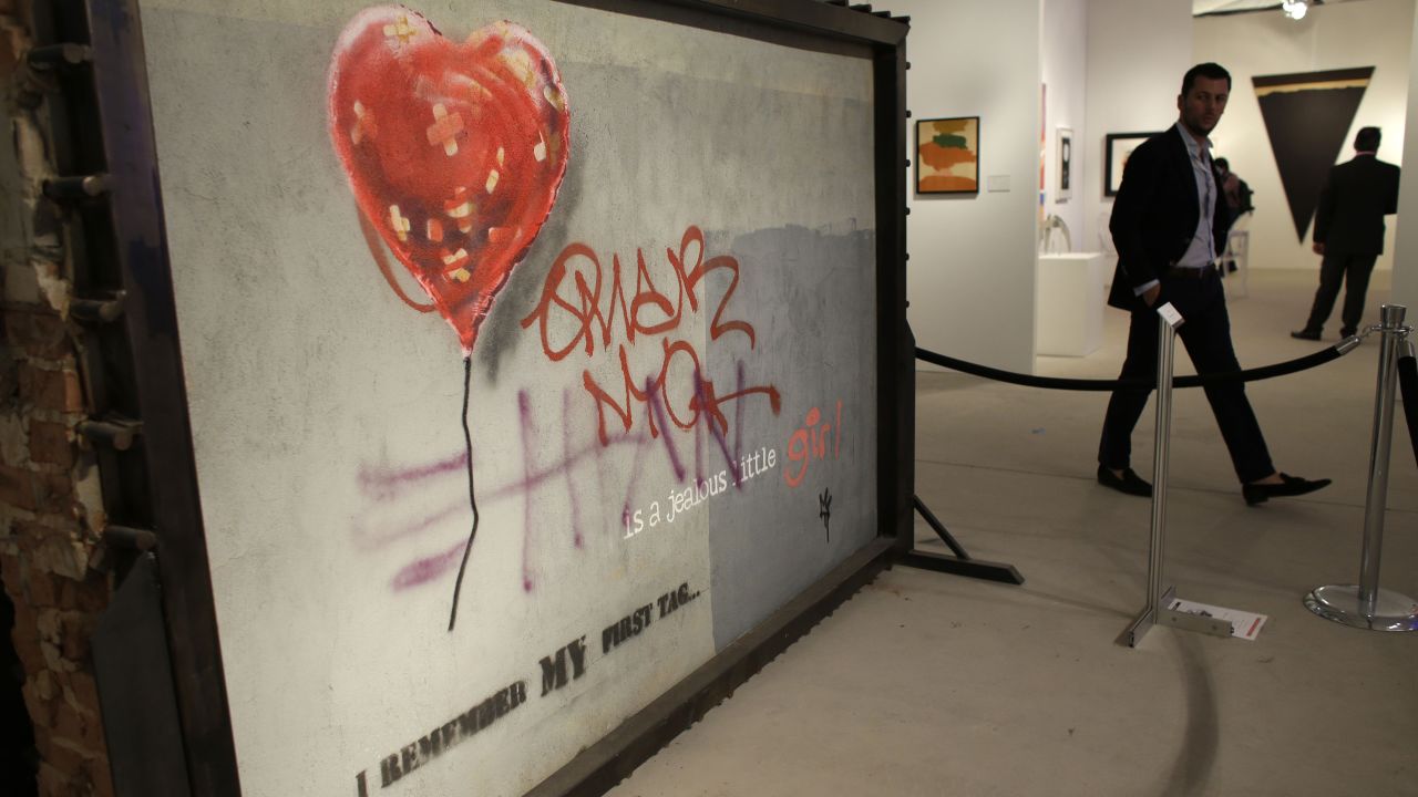A piece by graffiti artist Bansky titled "Brooklyn Bandaged Heart" is displayed at Art Miami, Sunday, December 8, in the Design District neighborhood of Miami. Art Basel, which ended December 8, featured works from 285 international galleries, representing 31 countries.