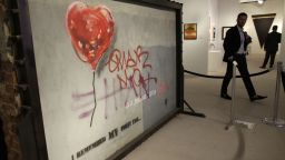 A piece by graffiti artist Bansky titled "Brooklyn Bandaged Heart" is displayed at Art Miami, Sunday, Dec. 8, 2013, in the Design District neighborhood of Miami. Art Miami is one of numerous satellite fairs that run in conjunction with Art Basel in Miami Beach.