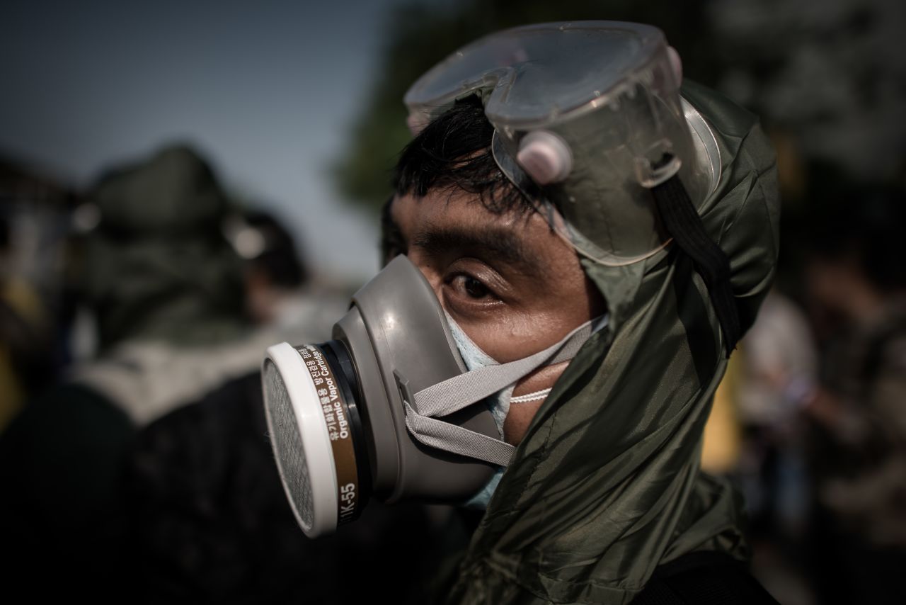 A demonstrator wearing a gas mask looks on outside a government building in Bangkok on December 9.
