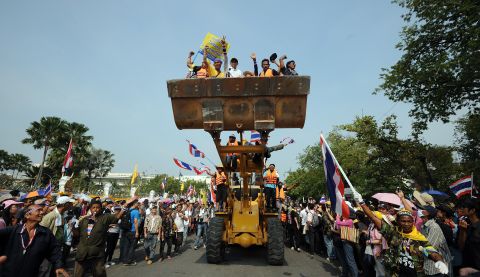 Anti-government protesters celebrate after removing concrete barricades outside the Government House in Bangkok on December 9.