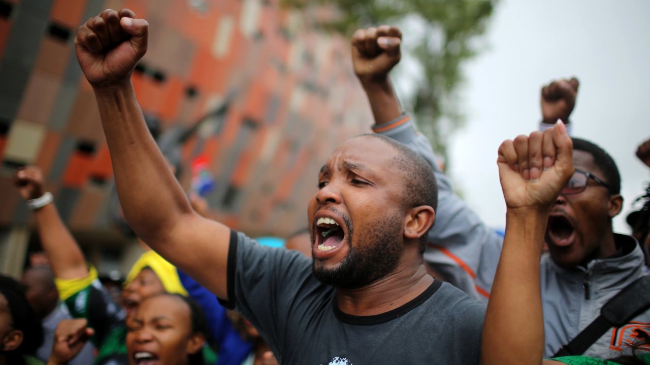 Members of the public sing and dance as they arrive for the memorial service at FNB Stadium.