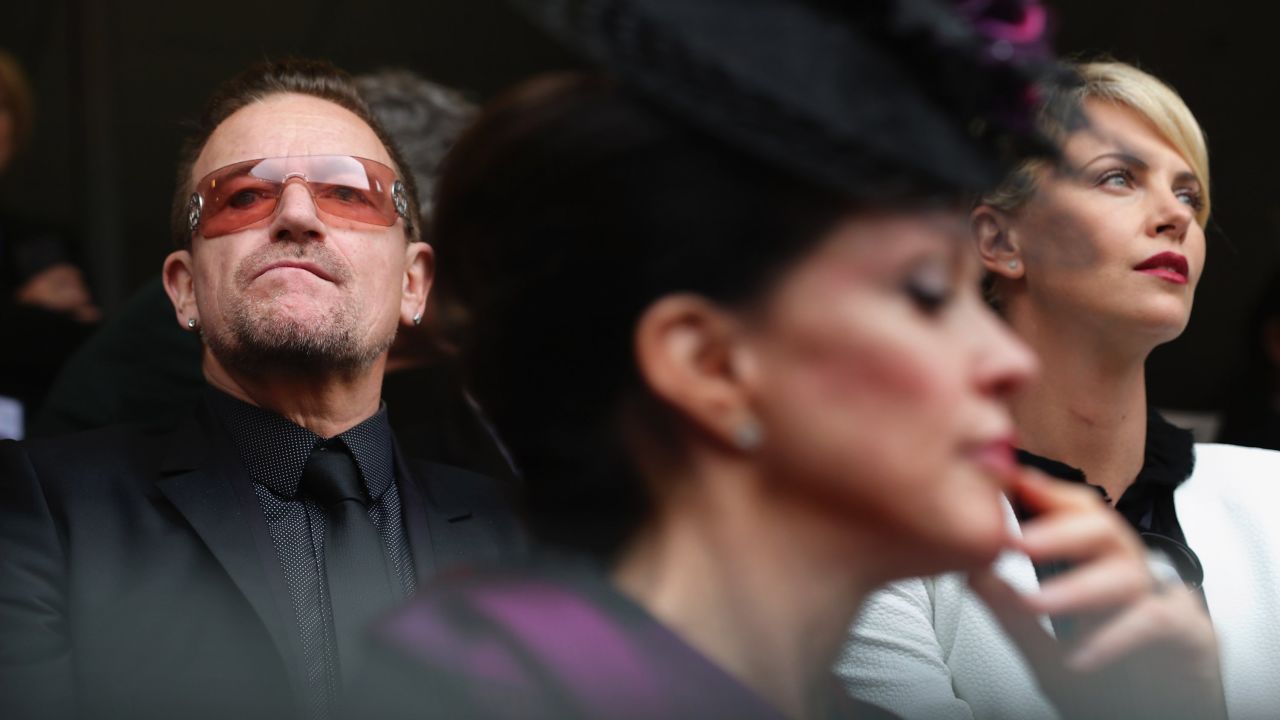 Singer Bono and actress Charlize Theron attend the memorial service.