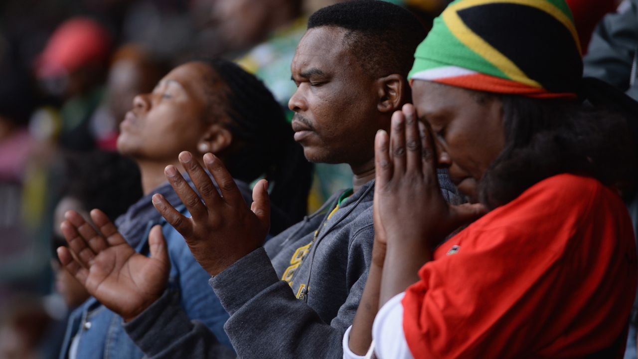 Mourners pause for a prayer during the memorial service.