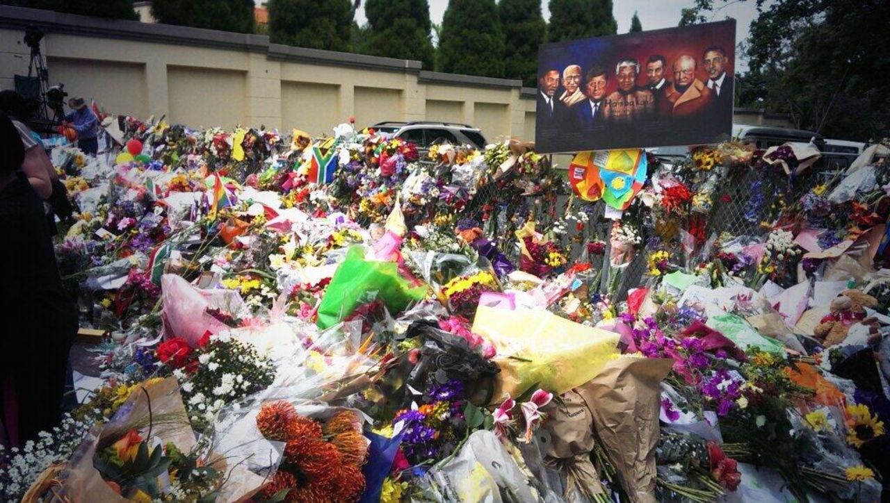 Visitors place flowers at a memorial for Mandela.
