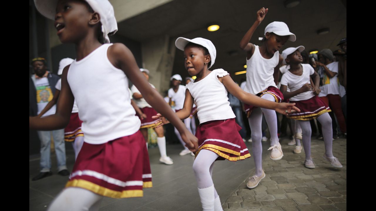 <strong>December 10: </strong>Girls dance during the memorial service for former South African President Nelson Mandela at FNB Stadium in Johannesburg. Thousands of South Africans and more than 90 heads of state gathered to honor the revered leader, who died on December 5. He was 95.
