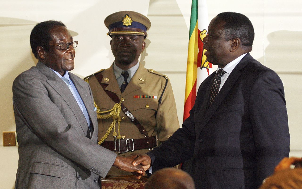 Zimbabwean President Robert Mugabe, left, shakes hands with Movement for Democratic Change leader Morgan Tsvangirai on July 21, 2008, in Harare after the signing of a deal between Zimbabwe's opposition and ruling party, paving the way for full-scale talks.