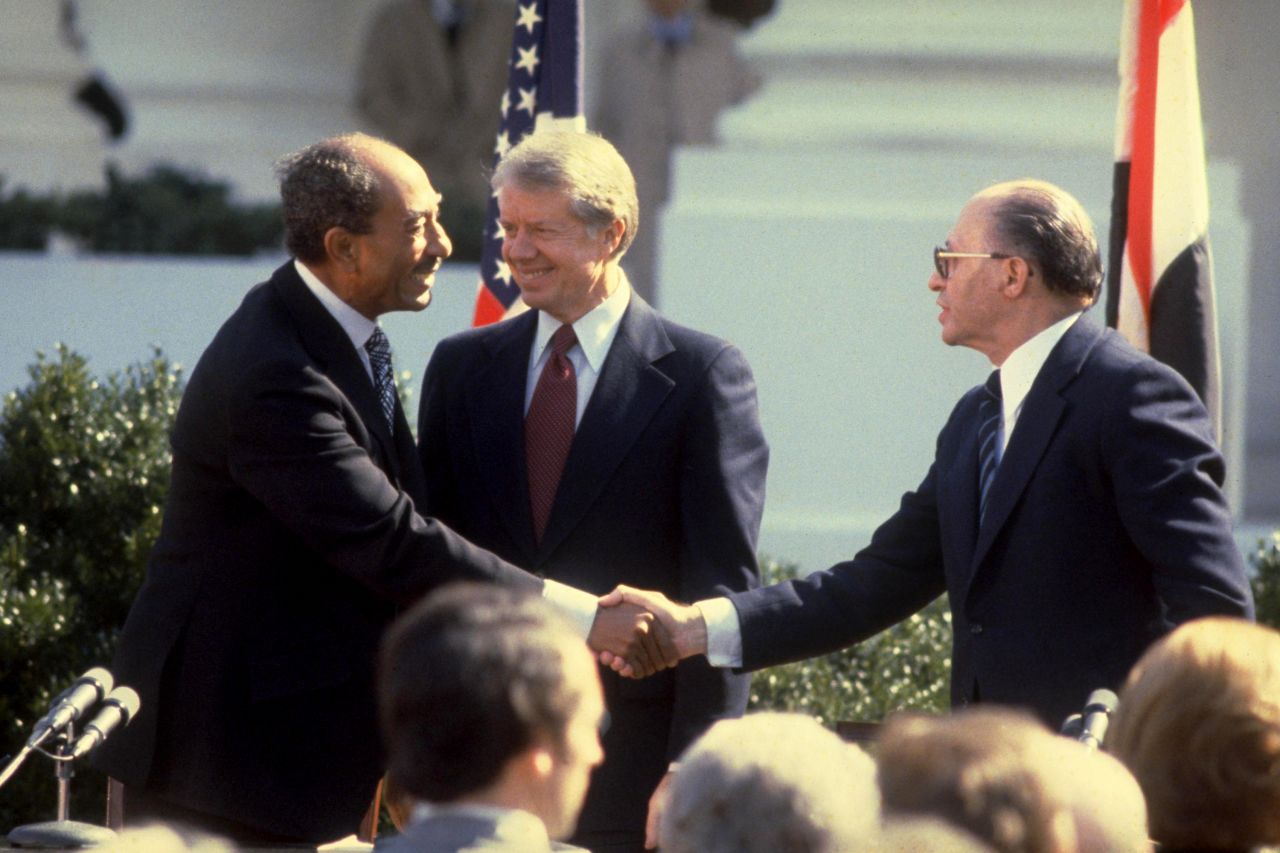 Egyptian President Anwar Sadat, left, and Prime Minister Menachem Begin shake hands after signing the Israeli-Egyptian peace treaty as U.S. President Jimmy Carter watches at the White House on March 26, 1979.
