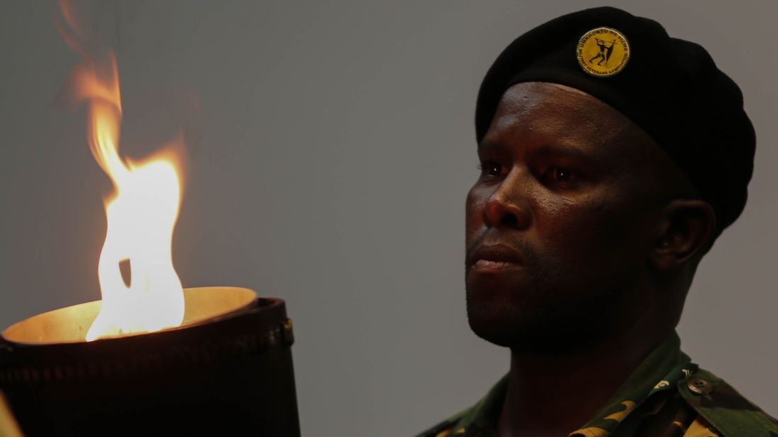 A South African soldier watches the flame of the torch before entering the field during the memorial service.
