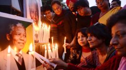 Indian members of the Akhil Bhartiya Human Rights Organisation (ABHRO) light candles in front of a placard bearing the image of South African former president Nelson Mandela during a vigil to pay tribute to Mandela on International Human Rights Day at the India-Pakistan Wagah Border post on December 10, 2013