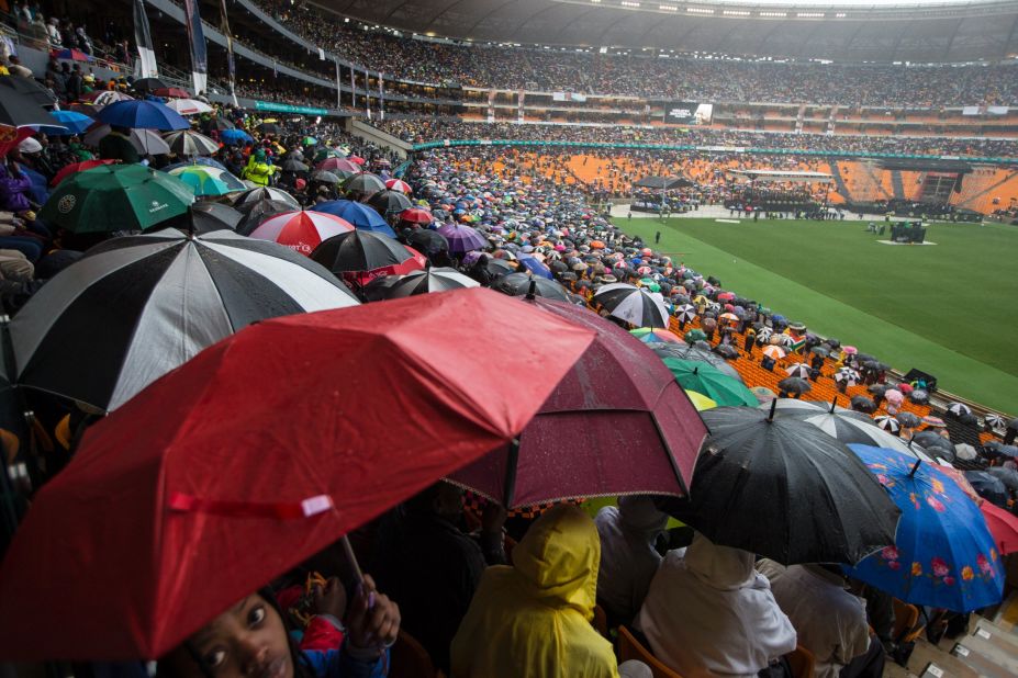 People in the stadium take shelter from the rain.
