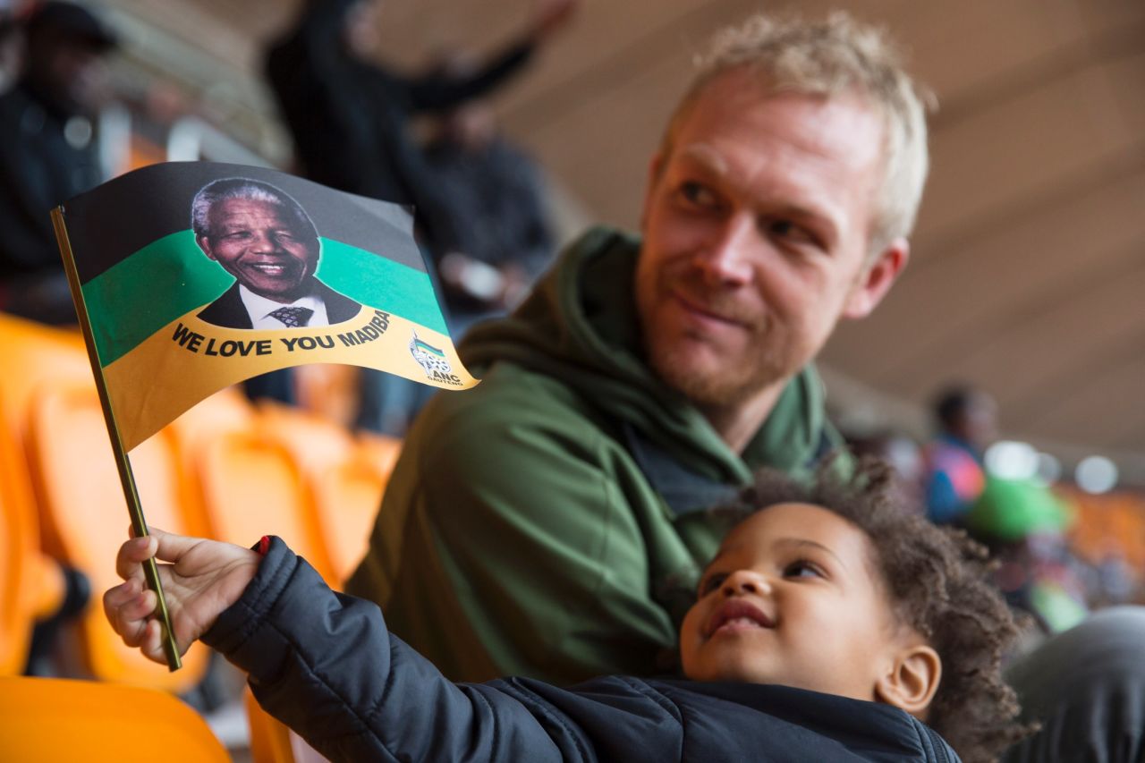 A young boy holds up a flag honoring "Madiba," Mandela's traditional clan name.