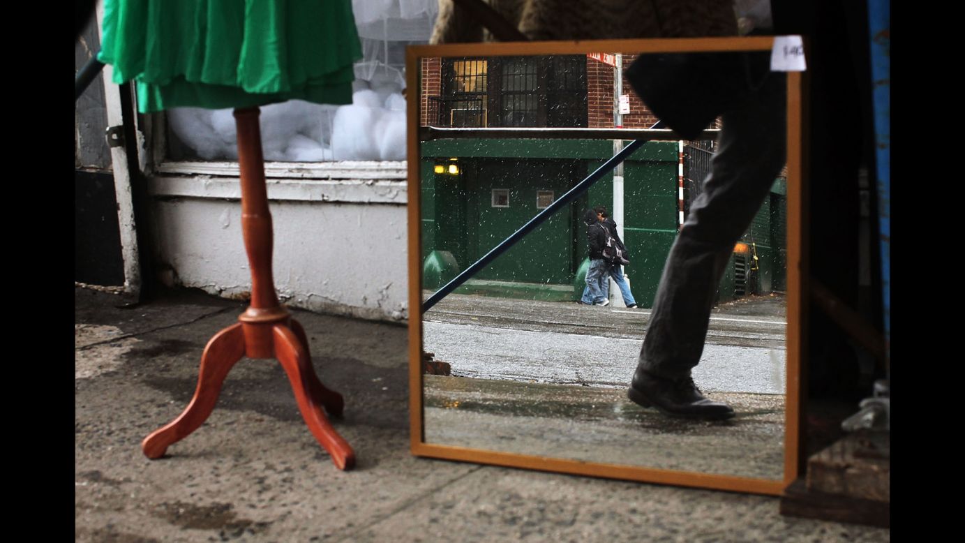 A mirror reflects light snow on a sidewalk in New York on December 10.