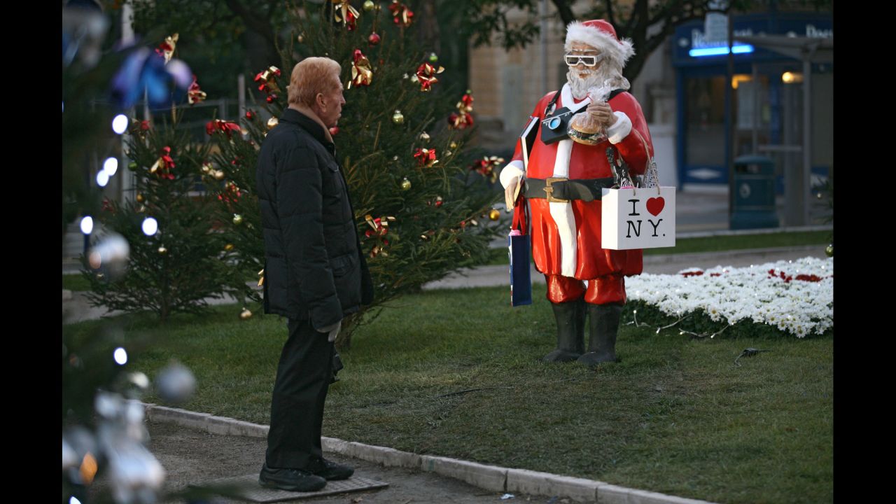 A man checks out a statue called "Santa Claus Tourist in the USA" in Menton, France, on December 9.