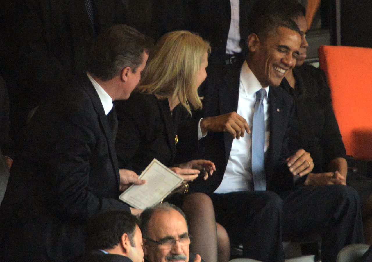Danish Prime Minister Helle Thorning-Schmidt shares a joke with U.S. President Barack Obama at the Nelson Mandela memorial as UK Prime Minister David Cameron looks on.