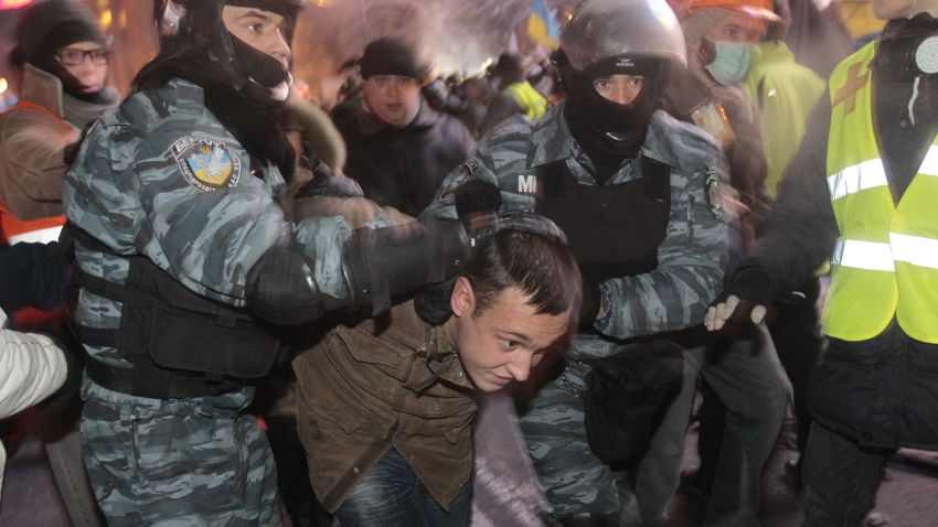 Ukrainian riot policemen pull a Pro-European Union activist out form a tent camps on the Independence Square in Kiev, Ukraine, Wednesday, Dec. 11, 2013. Security forces clashed with protesters as they began tearing down opposition barricades and tents set up in the center of the Ukrainian capital early Wednesday, in an escalation of the weeks-long standoff threatening the leadership of President Viktor Yanukovych. (AP Photo/Sergei Chuzavkov)