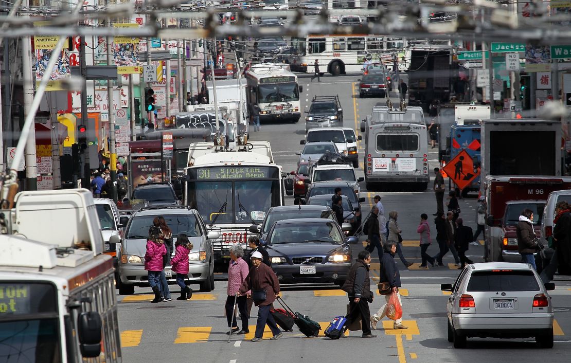 Cars and buses share the road along Stockton Street in San Francisco.