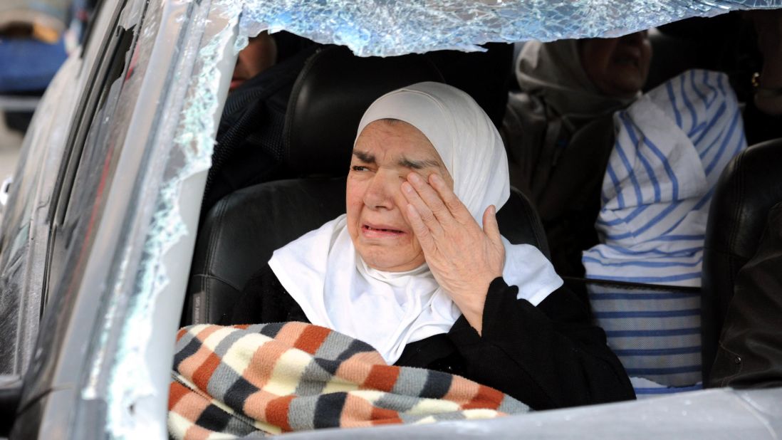 A woman weeps inside a damaged vehicle after forces loyal to President Bashar al-Assad captured the town of Nabak on Monday, December 9.