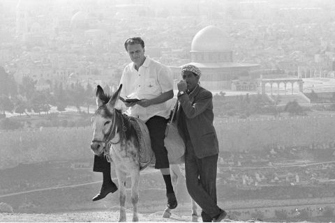 Graham rides a donkey in Jerusalem while visiting the city in 1969.