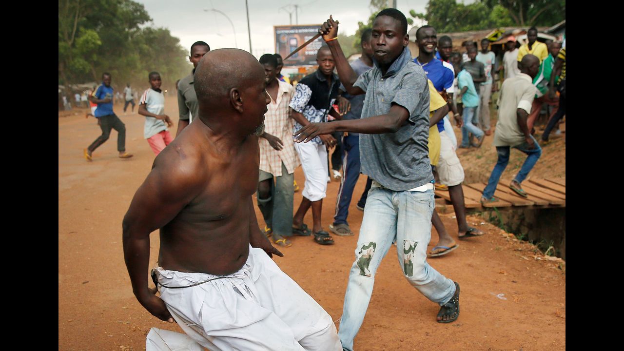 <strong>December 9:</strong> A Christian man chases a suspected Seleka officer in civilian clothes with a knife near the airport in Bangui, Central African Republic. The Seleka man was taken into custody by French forces, who fired warning shots to disperse the crowds. The Central African Republic is in the midst of a bloody civil war between various proclaimed Christian and Muslim militias and other rebel factions.