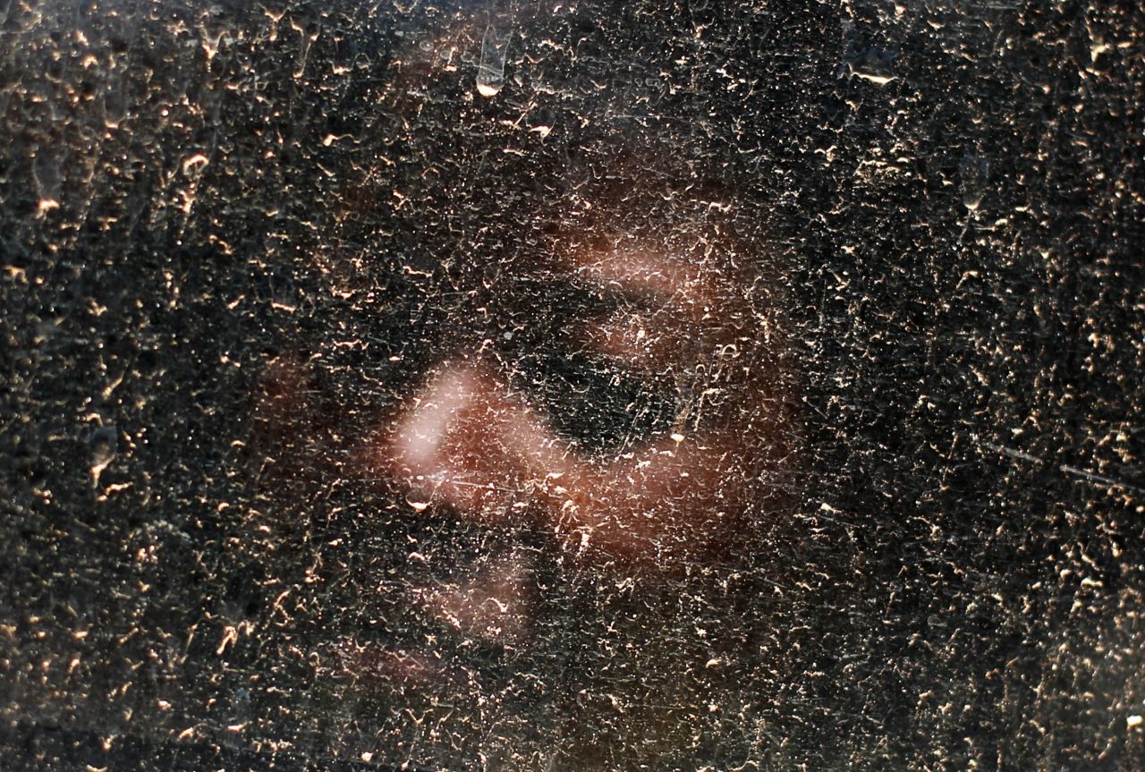 <strong>December 11:</strong> A woman looks out a dusty bus window on the way to see Mandela's casket in Pretoria, South Africa. The anti-apartheid icon's casket arrived in the country's capital for public viewing.