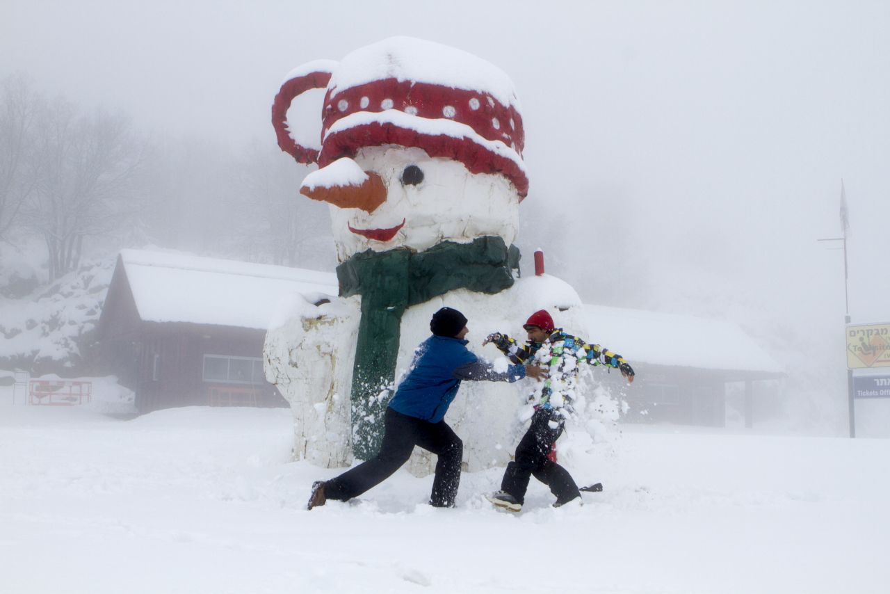 Israelis play next to a giant snowman on Mount Hermon in Golan Heights on December 11.