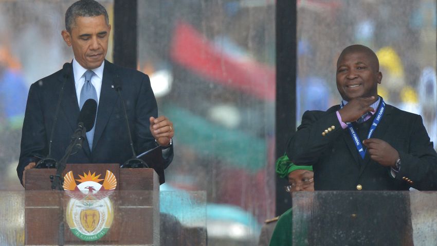 In this picture taken on December 10, 2013 US President Barack Obama delivers a speech next to a sign language interpreter (R) during the memorial service for late South African President Nelson Mandela at Soccer City Stadium in Johannesburg. South Africa's deaf community on December 11, 2013 accused the sign language interpreter at Nelson Mandela's memorial of being a fake, who had merely flapped his arms around during speeches. Mandela, the revered icon of the anti-apartheid struggle in South Africa and one of the towering political figures of the 20th century, died in Johannesburg on December 5 at age 95. AFP PHOTO / ALEXANDER JOE (Photo credit should read ALEXANDER JOE/AFP/Getty Images)
