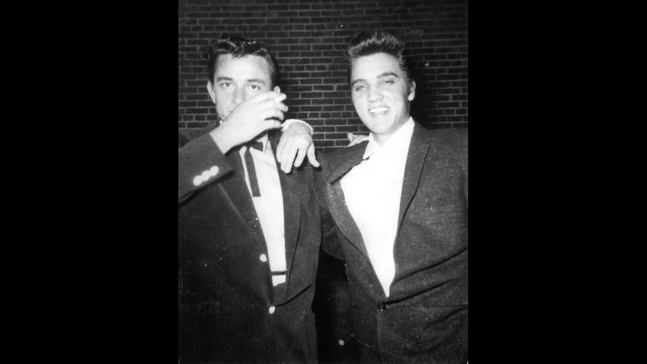 Cash, left, and Elvis Presley pose together in the 1950s.