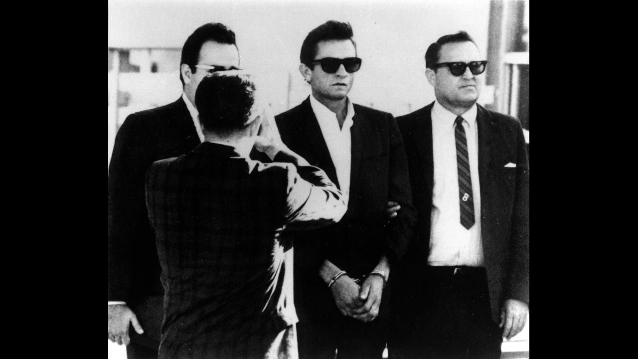 Cash, center, is flanked by a bondsman and a U.S. marshal as he is transferred to the federal courthouse in El Paso, Texas, on October 5, 1965. Cash was arrested and charged with importing and concealing over 1,000 pep pills and tranquilizers.