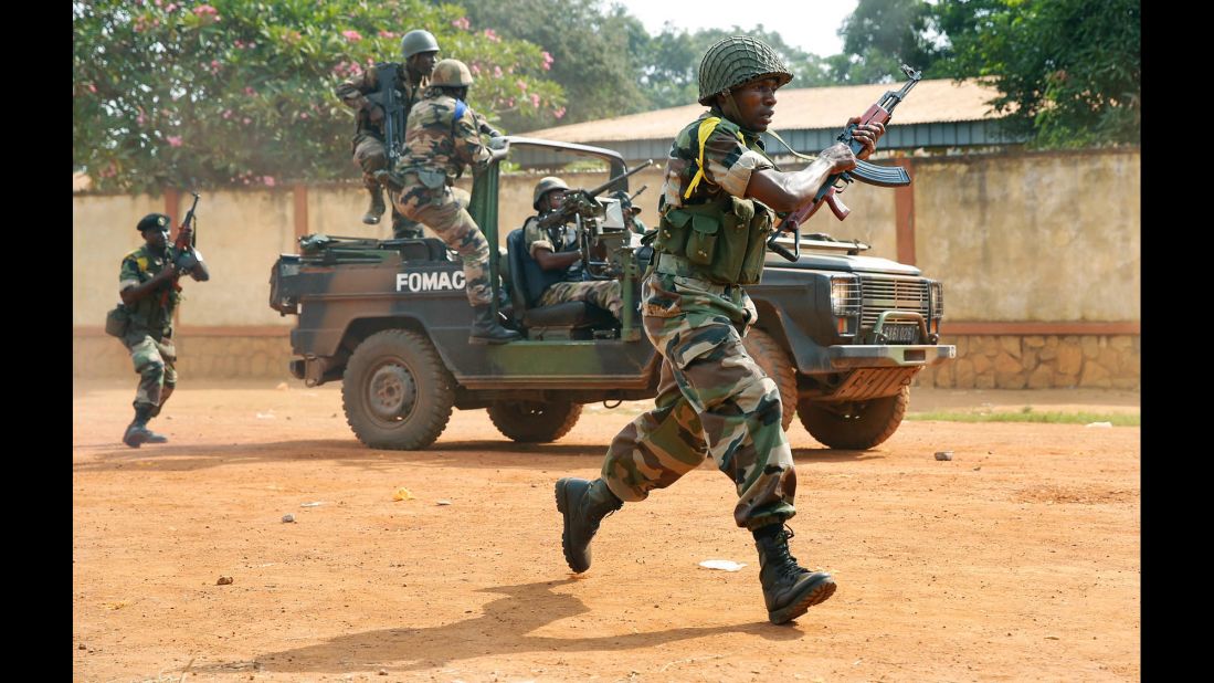 Peacekeeping troops from the Multinational Force of Central Africa shoot as they attempt to evacuate Muslim clerics from the St. Jacques Church in Bangui on Thursday, December 12. An angry crowd had gathered outside the church following rumors that a Seleka general was inside.