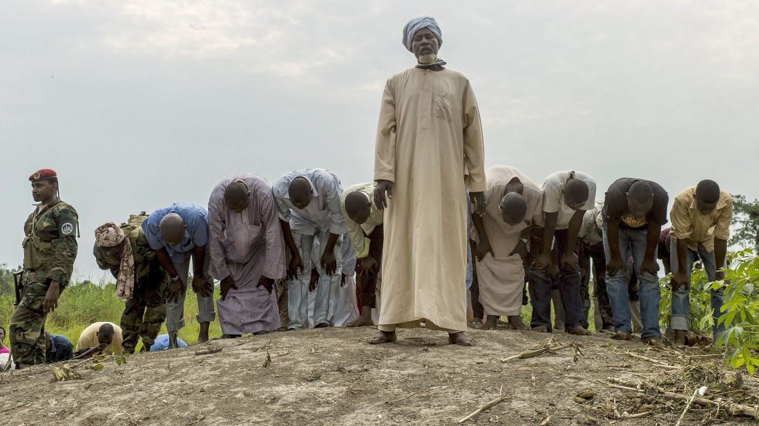 People pray as they bury 16 coffins in a Muslim cemetery in Bangui on December 11.